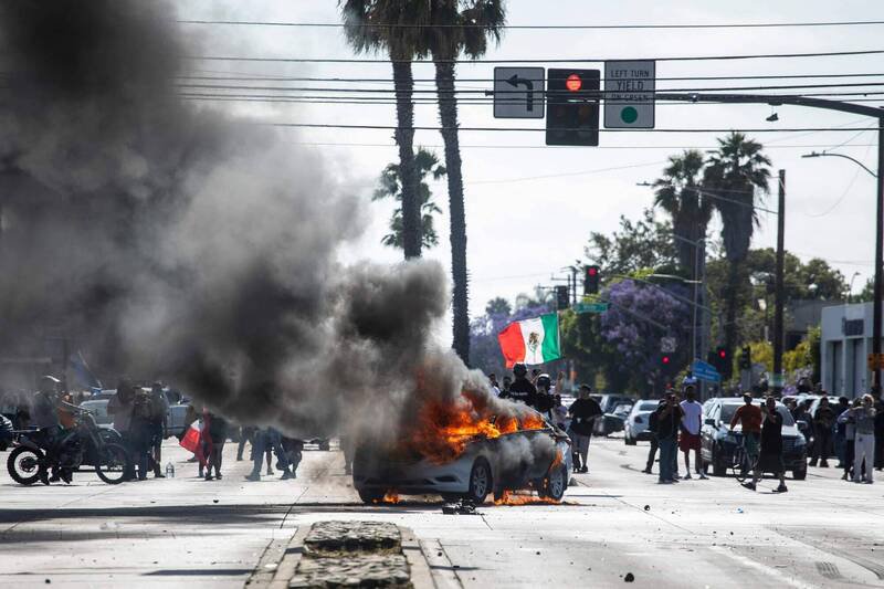 美国洛杉矶康普顿(Compton)地区6月7日爆发激烈抗议,一辆汽车在示威中遭焚烧。事件起因于联邦移民当局的扫荡行动。(法新社) 美国洛杉矶康普顿(Compton)地区6月7日爆发激烈抗议,一辆汽车在示威中遭焚烧。事件起因于联邦移民当局的扫荡行动。(法新社)