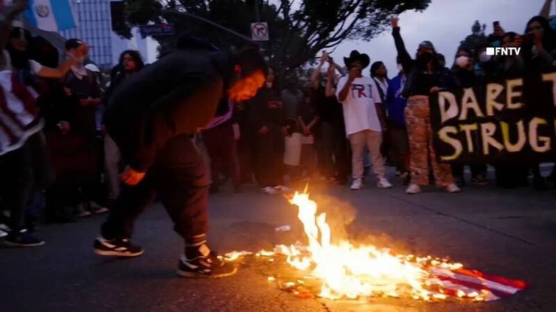 洛杉矶反移民暨海关执法局(ICE)示威中,一名男子朝燃烧中的美国国旗吐口水。(图取自FreedomNewsTV画面) 洛杉矶反移民暨海关执法局(ICE)示威中,一名男子朝燃烧中的美国国旗吐口水。(图取自FreedomNewsTV画面)