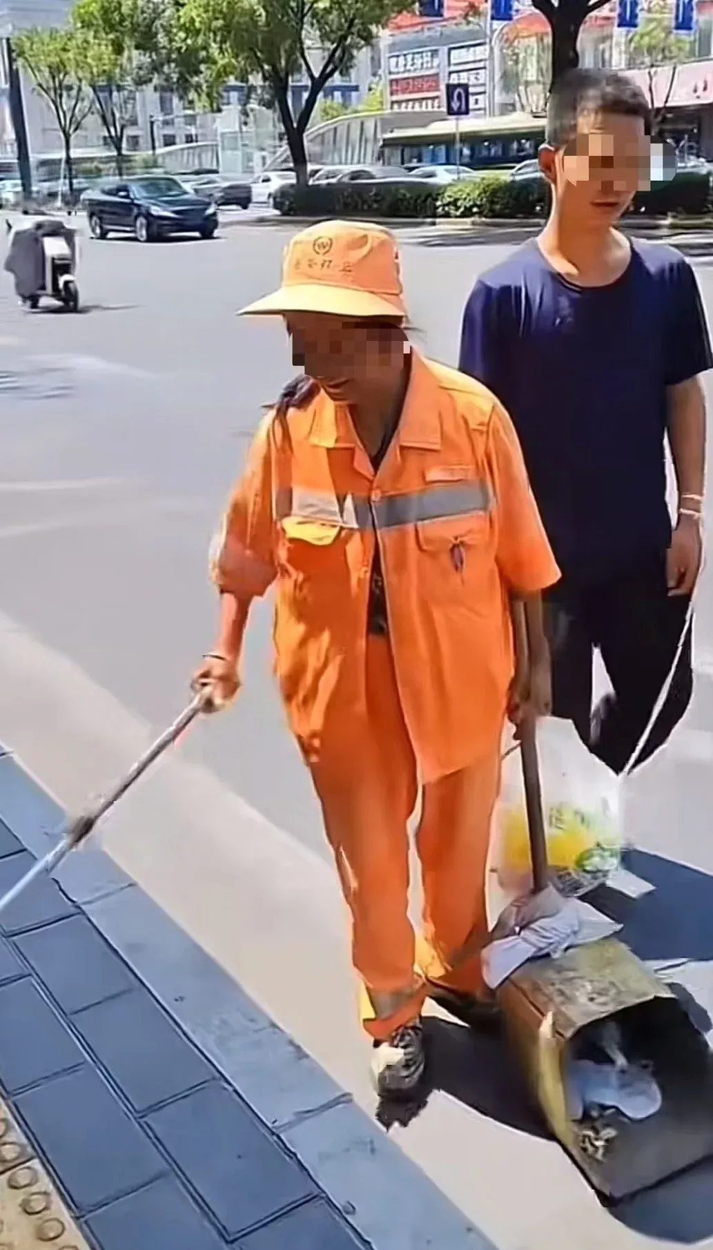 环卫工用绳牵智力障碍儿子扫街 她拒绝社会捐赠
