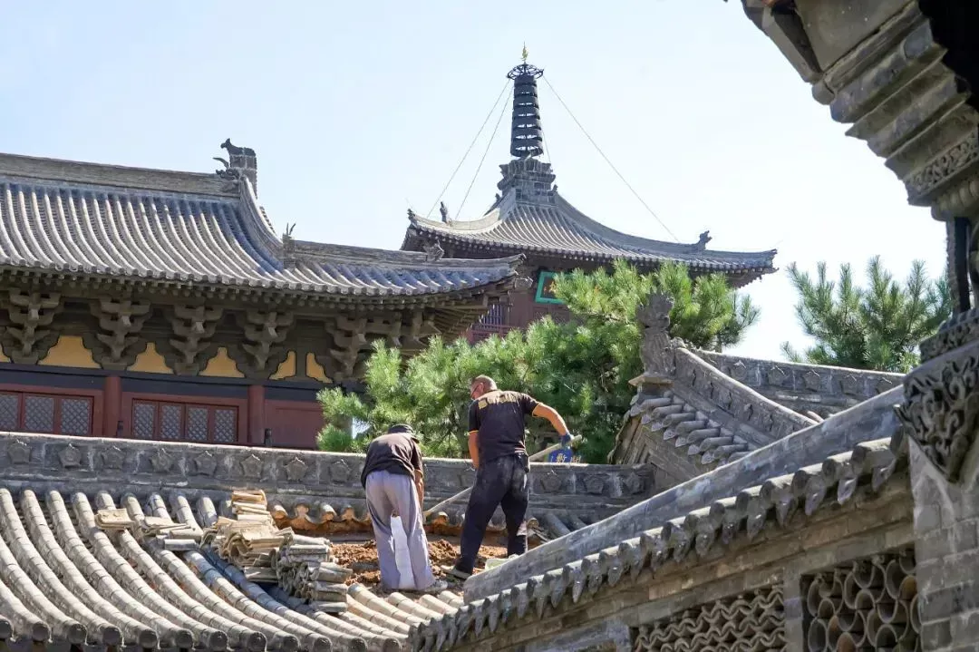 2023年,山西大同,工人在修缮华严寺的瓦顶。(图/视觉中国)