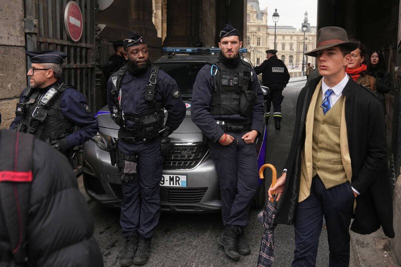 美联社摄影记者卡缪19日拍摄法国警方封锁发生窃案的罗浮宫1处出入口时,意外捕捉到1名打扮复古、但优雅的神秘男子(右),引发网路热议,甚至怀疑男子是AI生成。(美联社) 美联社摄影记者卡缪19日拍摄法国警方封锁发生窃案的罗浮宫1处出入口时,意外捕捉到1名打扮复古、但优雅的神秘男子(右),引发网路热议,甚至怀疑男子是AI生成。(美联社)