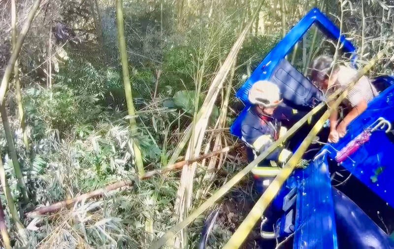 73岁妇人忍痛移动身体，钻到车门边后由消防救援人员将她拉出车外。（南投县消防局提供）