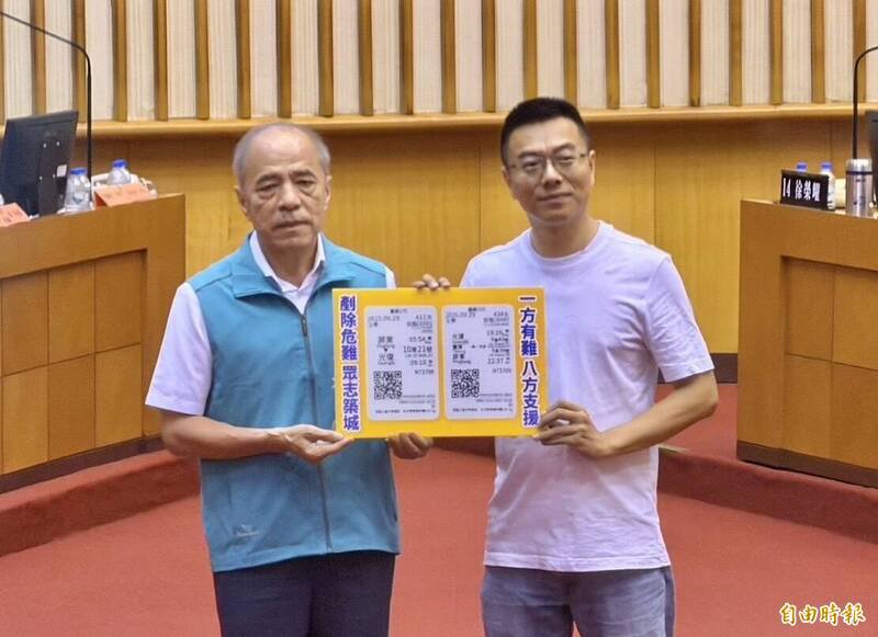 屏东县议员黄明贤（右）于议会质询时，送上其团队赴花莲光复救灾的车票放大版给消防局长李彬正（左）。（记者罗欣贞摄）