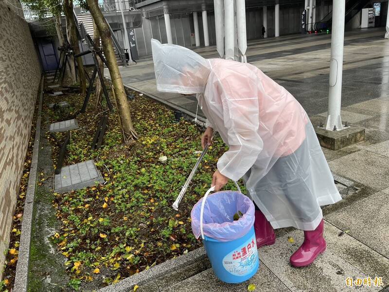清洁人员在城际转运站的大顶棚广场检拾烟蒂。（记者卢贤秀摄）