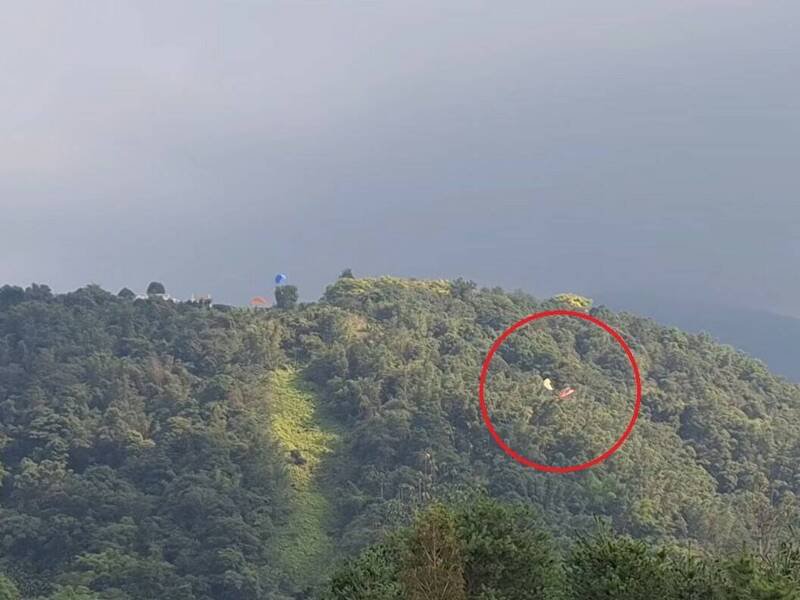 南投埔里虎头山发生飞行伞空中相撞（红圈处），之后2名伞友双双坠落树林，所幸挂树后皆已自行脱困。（图撷取自脸书「爆料公社公开版」）