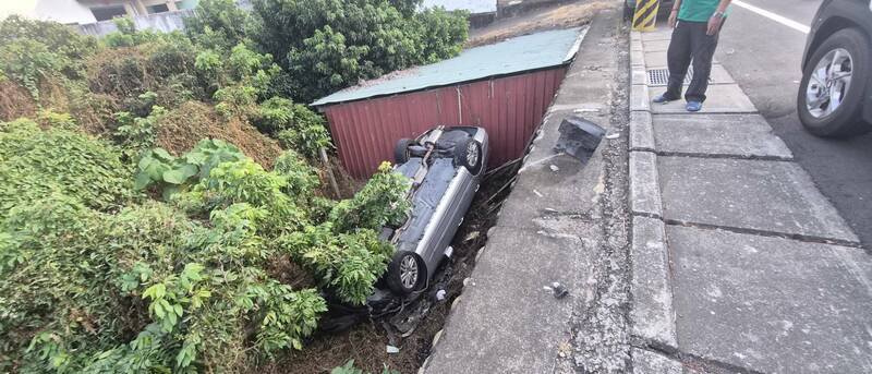 好好停放路边自小客车，却遭人擦撞掉落果园。（民众提供）