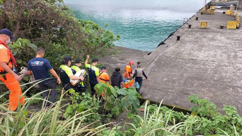 基隆市62岁张姓钓客，今天下午在八尺门渔港防波堤消波块上下竿时，突然昏倒在消波块上，基隆市消防局、海巡署第二岸巡队等单位，赶紧将他送医急救。（记者林嘉东翻摄）