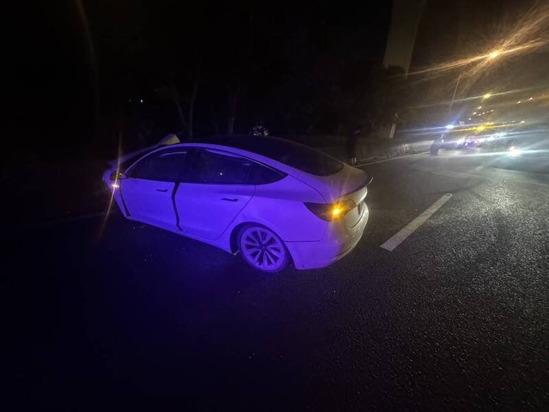 白色特斯拉轿车自撞内侧护栏失控往右侧冲入南崁交流道匝道。（记者余瑞仁翻摄）