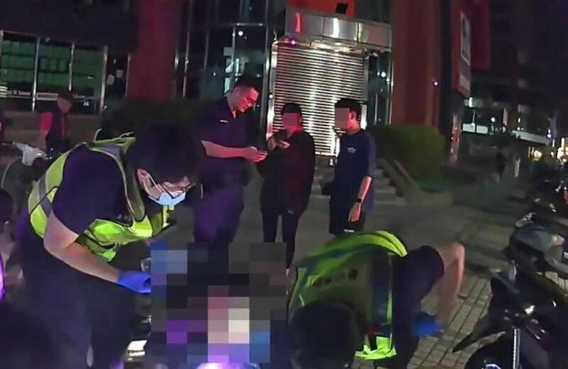 陈姓男子（中）被围殴倒地，员警叫救护车将他送医，发现头部、全身多处擦挫伤，手指也骨折。（记者陈建志翻摄）