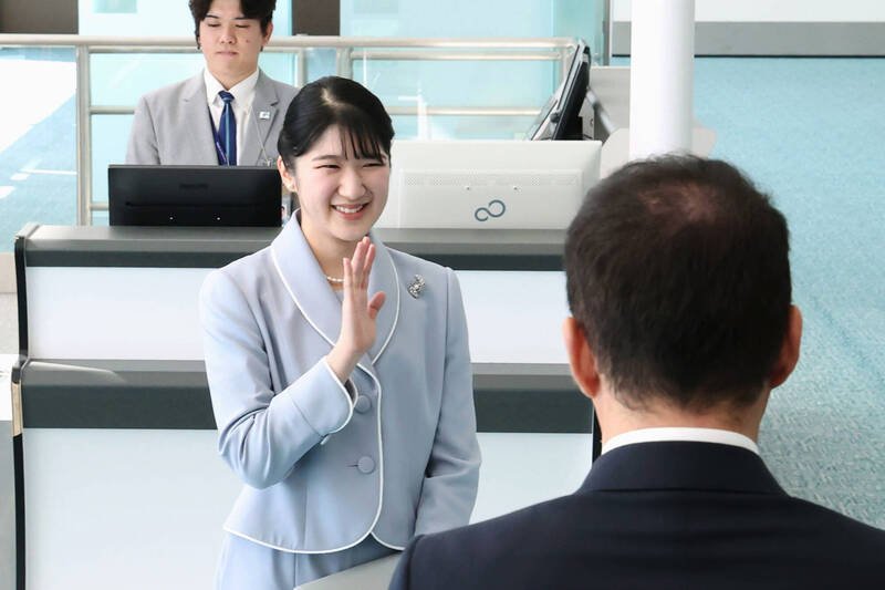 爱子公主身著水蓝色套装，带著笑容现身在东京羽田机场，并对来送行的宫内厅干部、采访记者挥手致意。（美联社）