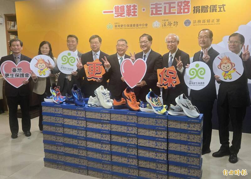 台湾更保会台中分会发起「一双鞋、走正路」计划，向友善企业募集全新的运动鞋赠与法务部矫正署，再由矫正机关转送经济弱势的出狱受刑人，图右四为法务部长郑铭谦、右五为更保台中分会主委廖学从、左四为法务部次长徐锡祥、右三为高检署检察长张斗辉。（记者王定传摄）