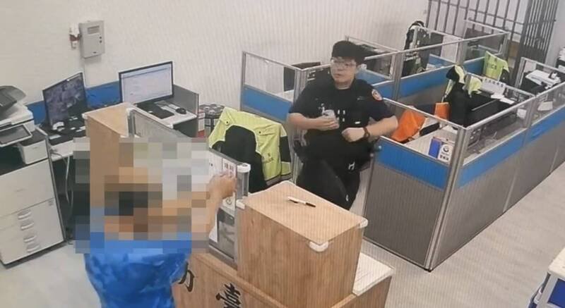 李姓男子涉嫌杀妻后，冷静走进内坜派出所自首，并伸出双手作势希望警方上铐。（记者李容萍翻摄）