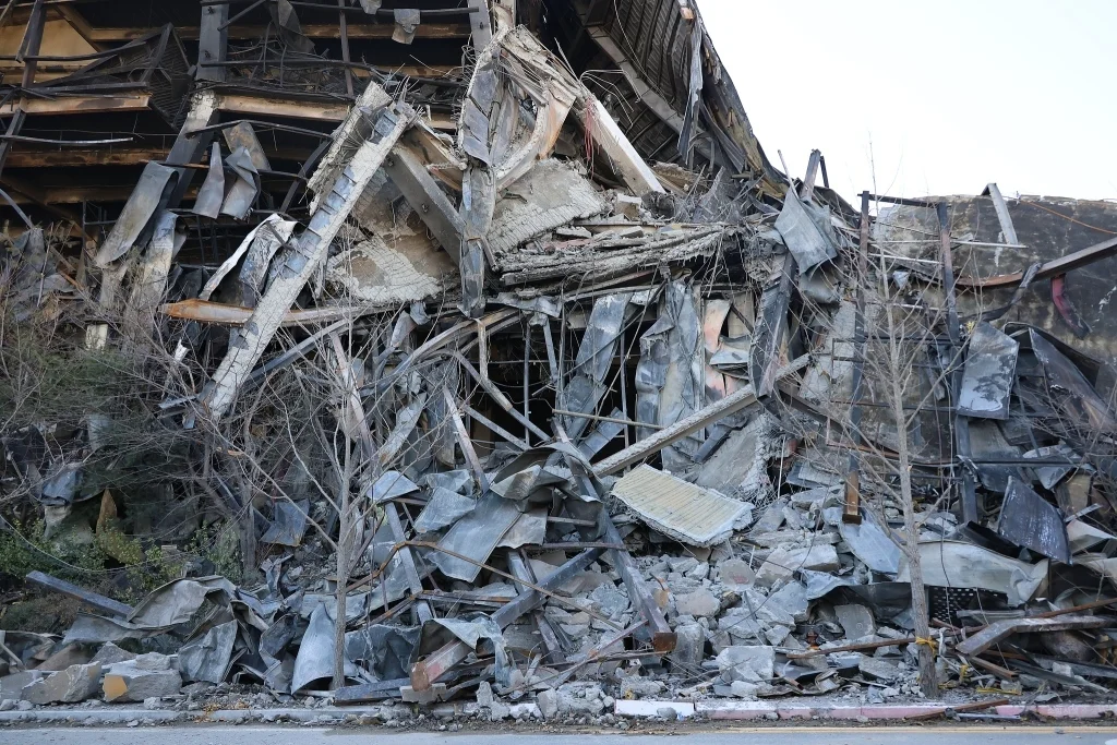 当地时间2025年11月21日，韩国忠清南道天安市，衣恋集团(E-LAND)时尚物流中心发生火灾后，建筑残骸散落在人行道上。视觉中国 图