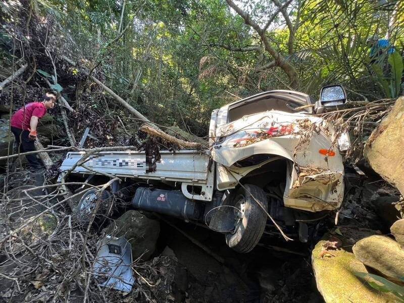 警消人员移走杂木、竹子，准备将死者拉出。（民众提供）