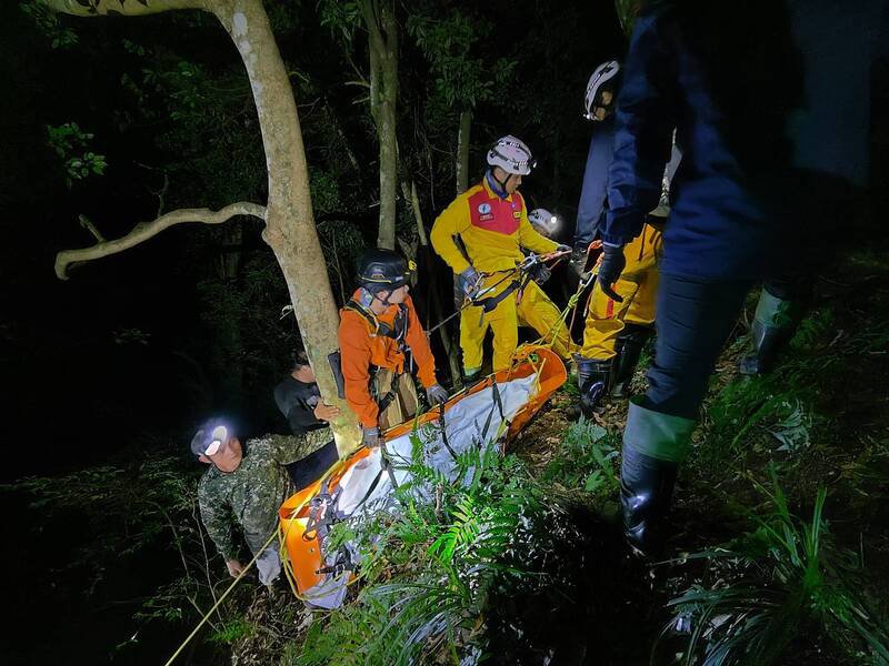 搜救队伍前后花了15小时才找到吕姓猎人遗体，费尽千辛万苦接力运回登山口。（桃园市消防局提供）
