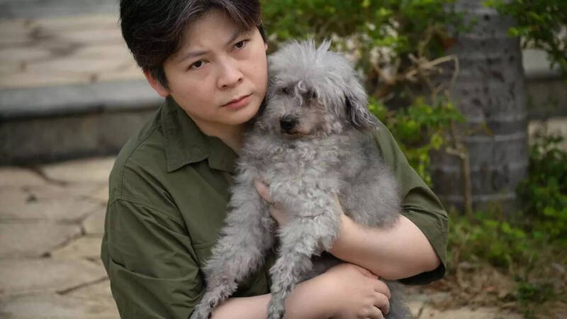 饲主李小姐（左）与获救的15岁贵宾狗「杰森」重逢，她感谢消防员不仅救了狗，更「救了她的灵魂」。（法新社）