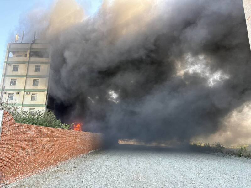 大火烧出浓烟直窜天际，险些波及一旁大楼。（消防局提供）