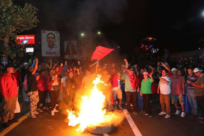 宏都拉斯自由重建党支持者9日聚集在首都存放选票的大楼外抗议，部分人甚至纵火点燃落叶及轮胎。（欧新社）