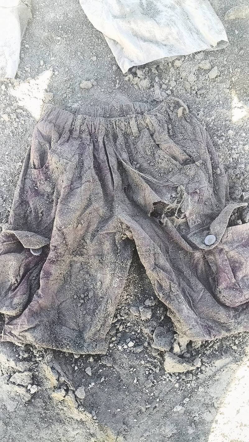 现场挖到的裤子，家属认为就是父母亲穿过用过的物品。（民众提供）