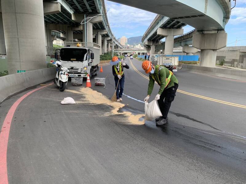 新北市五股一辆货车漏油，导致一名机车骑士摔车，警方到场维护交通。（记者吴仁捷翻摄）