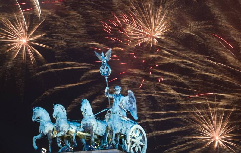 德国跨年烟火每年造成大量伤患，引发政府是否应全面禁放烟火的争辩。图为柏林勃兰登堡门上空绽放绚丽的烟火。 （美联社）