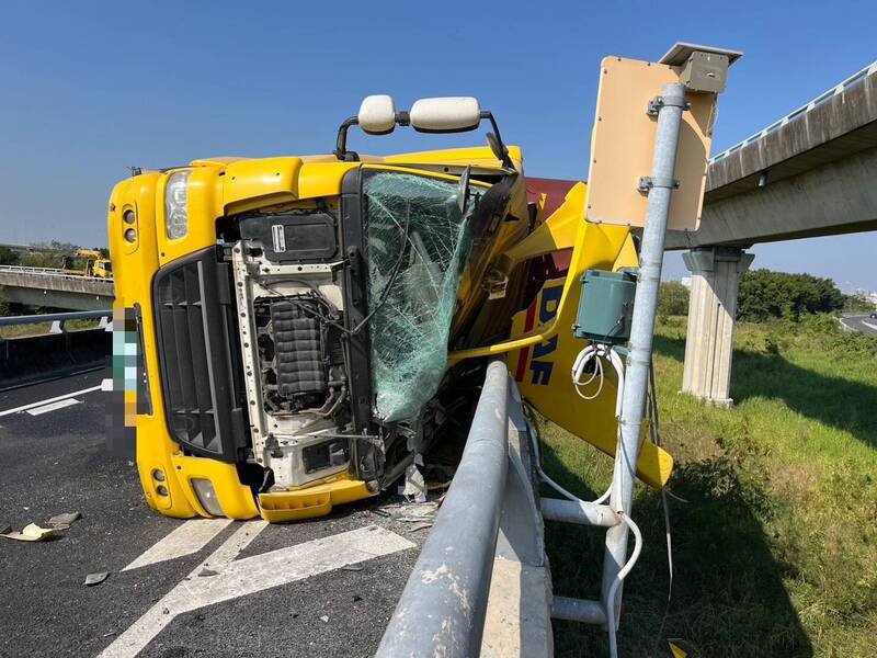 1辆营业半联结车从国1北向台南系统汇国8西行时，疑车速过快自撞护栏侧翻。（读者提供）