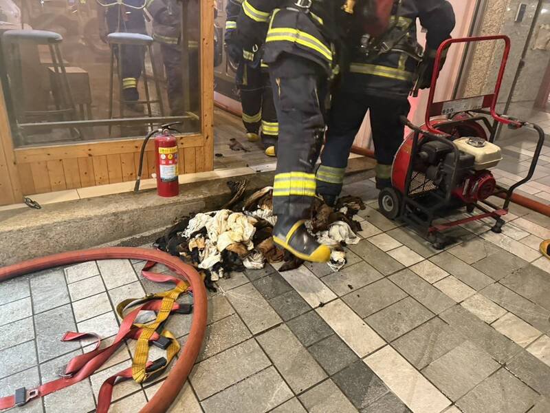 消防人员拿出烘衣机里的毛巾与衣物。(记者徐圣伦翻摄) 消防人员拿出烘衣机里的毛巾与衣物。(记者徐圣伦翻摄)