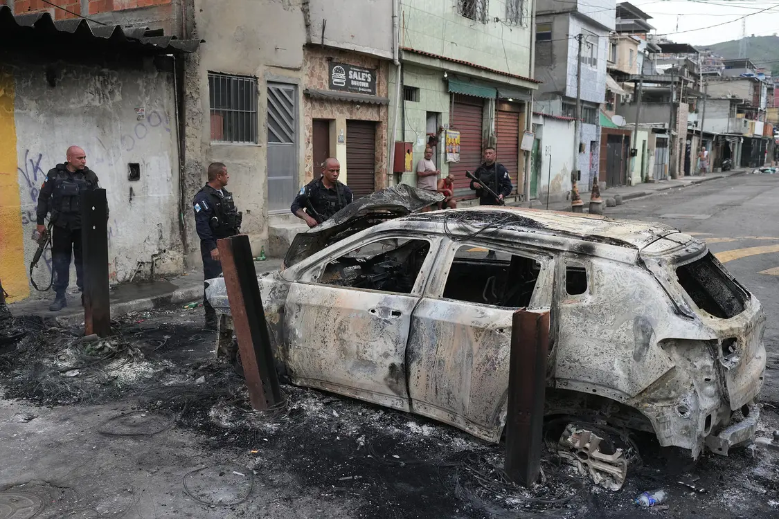 ▲10月28日,里约热内卢警察查看一辆被焚毁的汽车 图据视觉中国
