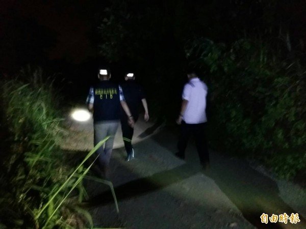 新北市29岁林姓男子与27岁林姓女子同居，24日深夜林男打死同居人女童，花16小时从新北开到桃园寻找弃尸地点。图为警方在一片漆黑的公墓地区漏夜搜寻采证。（记者郑淑婷摄）