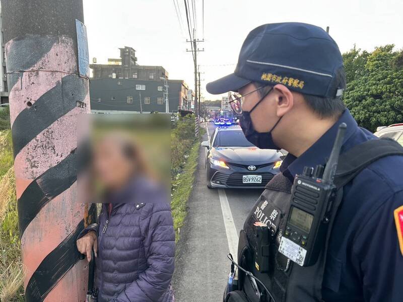 桃园吴姓阿嬷被车流吓到「抱电杆」，平镇警暖送她回家。（警方提供）