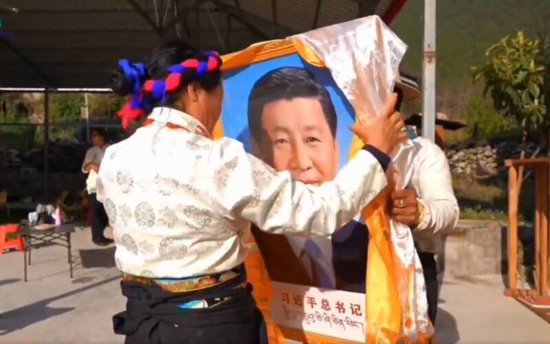 藏民手举「习近平总书记」的相框,还搭衬白布和黄布。(取自萨格尔扎西SakarTashi X 影片) 藏民手举「习近平总书记」的相框,还搭衬白布和黄布。(取自萨格尔扎西SakarTashi X 影片)
