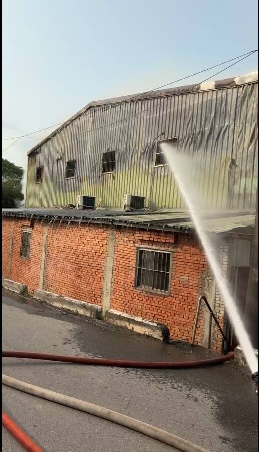 新北市八里一处老宅今天下午窜出火势，消防到场在前阳台救下一人送医，起火原因仍待调查厘清。（记者吴仁捷翻摄）