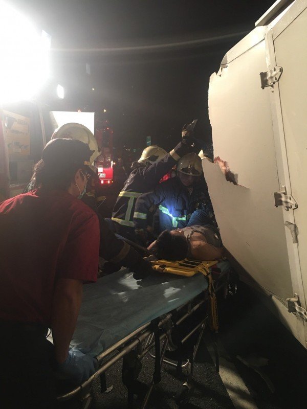 警消人员将受困的钱姓驾驶送医。（记者曾健铭翻摄）