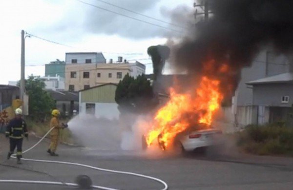 百万进口名车被大火吞噬，消防人员喷水灌救。（记者汤世名翻摄）